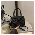 Détail d'un sac à main noir pailleté avec nœud 3D et élégantes ferrures dorées - Noir