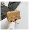 Borsa a tracolla trapuntata kaki con catena dorata tenuta da una modella in stile chic - Kaki