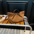 Borsa tote leopardata con manici marroni e tracolla su una panchina di legno - Marrone