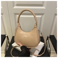 Detalle del bolso de media luna beige con textura de cuero y correa ajustable - Caqui