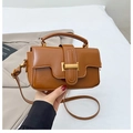 Detail of a brown leather handbag featuring a gold metal clasp and a top handle - Brown