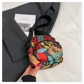 Gros plan détaillé d'un mini sac bandoulière en toile avec imprimés tropicaux colorés - Feuille