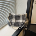 Bolso bandolera de tweed a cuadros grises y blancos con cadena dorada en entorno moderno - Blanco