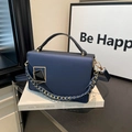 Navy blue chain crossbody bag for women with geometric buckle on a book setting - Blue