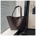 Detalle del bolso tote de piel de cocodrilo sintética marrón oscuro bajo luz natural - café