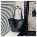 Detalle del bolso tote negro con textura de cocodrilo y acabado brillante grabado - Negro