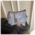 Detalle del bolso tote vintage gris con ribete de cuero sintético marrón y etiqueta de moda - Azul