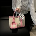 Fashionable canvas tote bag with pink trim, matching mini charm and silk scarf handle - Pink