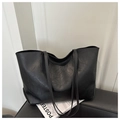 Minimalistische zwarte tote bag van zacht geolied leer op een stijlvolle kruk - Zwart