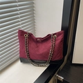 Bolso tote acolchado burdeos con base de cuero negro y cadena dorada junto a ventana - Rojo