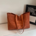 Sac fourre-tout en daim marron avec logo circulaire sur surface minimaliste en marbre - Marron