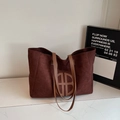 Sac cabas chic marron foncé en daim avec logo en cuir sur une surface en marbre - Marron