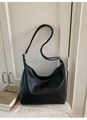 Detalle de bolso hobo retro negro con costuras verticales sobre fondo de madera blanca - Negro