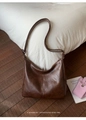 Detalle del bolso hobo retro marrón oscuro en cuero PU con textura vintage y costuras - café