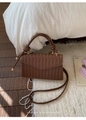 Detail of dark brown woven faux leather handbag with V-shaped flap and braided handle - Coffee