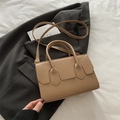Bolso estructurado de cuero caqui sobre traje gris con detalles de corte de escudo - Caqui