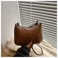 Close-up of a deep brown half-moon crossbody bag with decorative stitching details - Brown