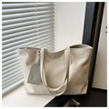 Detalle del bolso tote grande con textura arrugada y colgante decorativo gris - Blanco