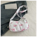 Nahaufnahme der sichelförmigen Segeltuchtasche mit Rosenmuster und Schleifen - Weiß