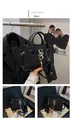 Detalle de bolso negro de cocodrilo con logo S dorado y colgante de borla elegante - Negro