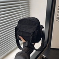 Minimalist black corduroy crossbody bag with adjustable strap and woven zipper pull detail - Black
