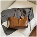 Dettaglio di una borsa tote in pelle lucida marrone scuro con ciondoli a tema baseball - Marrone (Con Ciondolo)