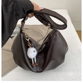 Detail of dark brown crescent shoulder bag with fuzzy monster charm and gold zipper - Coffee with Pendant