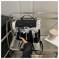 Detalle de mochila de cuero negro con encaje blanco y lazo en un estante - Negro