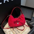 Elegant red suede crossbody bag with heart pendant displayed in a luxury boutique gift box - Red