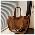 Detalle de un bolso tote de pana marrón con textura de rayas y correa ajustable al hombro - Marrón