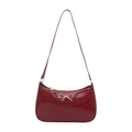 Chic burgundy patent leather shoulder bag featuring a gold bow metallic clasp - Red