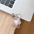 Macro detail of clear bear phone grip with a fuzzy pink heart on a silver laptop - Adhesive Folding Style / Pink