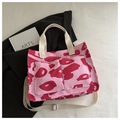 Dettaglio della borsa tote in tela rosa con macchie rosse e struttura multi-tasca - Rosa