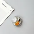 Detail of round phone grip with silver brushed metal sphere and amber resin insert - Silver Foil Style 1
