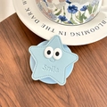 Détail du support de téléphone en forme d'étoile en cuir bleu clair avec sourire brodé - Rose bonbon