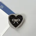 Detalle de soporte de móvil en corazón con lazo de strass y textura de purpurina negra - Corazón Lazo Magnético Diamantes-Lentejuelas / Negro