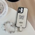 Detail of white leather iPhone case with rhinestone butterfly and beaded pearl hand strap - Large Hole Pearl Pattern - Silver Butterfly Logo - White Pearl Chain - White / iPhone 17 Pro Max