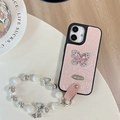 Detail of pink leather iPhone case with crystal butterfly charm and pearl wrist strap - Large Hole Pearl Pattern - Silver Butterfly Logo - White Pearl Chain - Pink / iPhone 17 Pro Max
