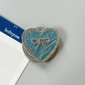 Detalle macro del soporte de corazón para móvil con cuero azul y lazo de pedrería - Corazón Lazo Magnético Diamantes-Textura Perla / Azul