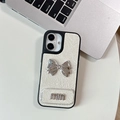 Detalle de funda de cuero crema con lazo plateado y adorno con el logotipo min - Blanco Perlado / iPhone 17 Pro Max