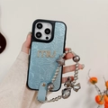 Detalle de funda iPhone de cuero azul claro con pedrería MU y cadena de estrellas - Perlado Diamante Letra M Cadena Estrella - Azul / iPhone 17 Pro Max