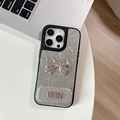 Close-up of silver crinkled leather iPhone case featuring a 3D bow and mirror detail - Large-hole Pearlescent Texture - Matching Mirror Stand - Mini Bow - Silver / iPhone 17 Pro Max