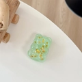 Sparkly glitter bear phone grip with golden stars on a clean white desk surface - Telescopic Stand Style / Dark Green