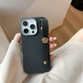 Close-up of black lychee leather iPhone case with gold camellia flower and wrist strap - Black / iPhone 17 Pro Max