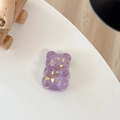 Macro detail of a purple glitter bear phone grip with gold star sequins on a white desk - Telescopic Stand Style / Purple