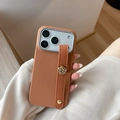 Detail of caramel leather iPhone case with camellia metal buckle and wrist strap - Brown / iPhone 17 Pro Max