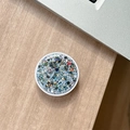 Close-up of a round phone grip with colorful glitter and sequins on a wooden desk - Black High Shine Sequin