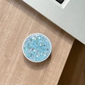 Macro shot of circular blue glitter sequins phone socket holder on wooden desk - Blue High Shine Sequin