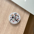 Macro shot of circular phone socket with colorful sequins on a wooden desk - Colorful Sequins No.2