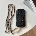 Dettaglio custodia in pelle nera con porta carte a fiocco e catena con perle - iPhone 17 Pro Max / Portafoglio Da Polso Triangolare Big Eye - Catena In Pelle Perlata - Nero